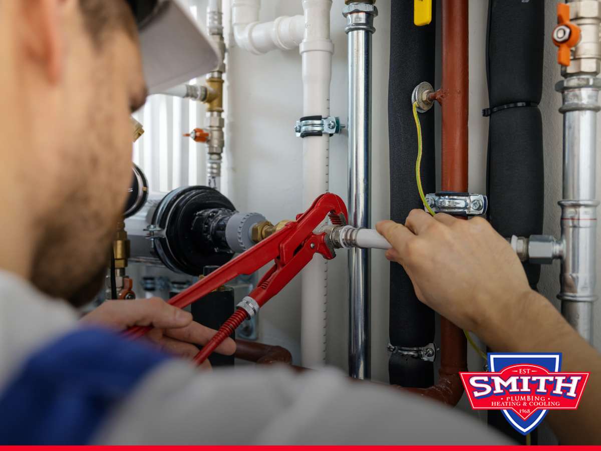 Plumber working on a home’s plumbing system with a wrench